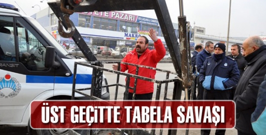 ÜST GEÇİTTE TABELA KAVGASI